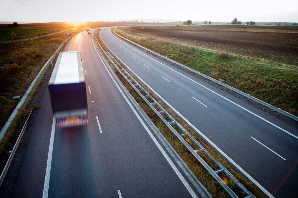 Freight truck on an open highway at sunrise